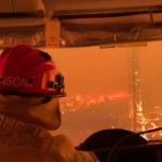 Photo looking out from the drivers cab of a firetruck in a forest fire in Australia.